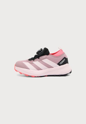Hellrosa und schwarze Adidas Terrex Sneaker mit weißen Streifen und einem Drehverschluss, für Outdoor-Aktivitäten entwickelt, seitlich dargestellt.
