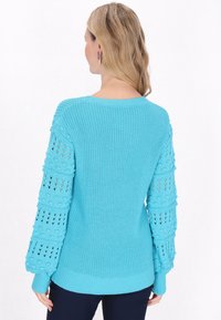 Pulover tricotat de culoare turquoise, cu mâneci tip puff texturate și detalii din tricotaj deschis, manșete cu nervuri și decolteu rotund.