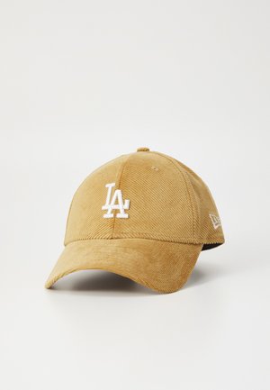 Brown corduroy baseball cap with a white embroidered "LA" logo on the front and a logo on the side. Curved visor and adjustable back.