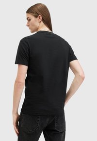 Sort bomulds t-shirt med korte ærmer og rund hals, med en glat overflade og en afslappet pasform, vist fra ryggen.