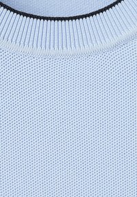 Tissu tricoté bleu clair avec un col côtelé présentant un bord fin foncé, montrant un motif tissé texturé.