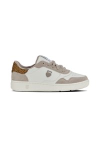 Baskets blanches avec un bout et un talon en cuir suédé beige, ornées d'un accent à imprimé léopard, lacets ronds et une semelle en caoutchouc texturée. Logo K-Swiss affiché.