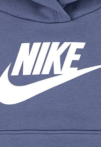 Hanorac Nike din țesătură albastră heathered, având un mare logo alb și designul Swoosh afișat proeminent pe față.
