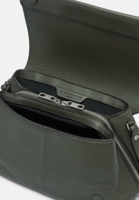 Borsa a tracolla in pelle verde scuro con chiusura a zip, tasca interna e hardware metallico. Texture liscia e design strutturato.