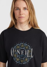 Must sulgri t-särk, millel on ümmargune graafika sinise ja rohelise tekstiga "O'Neill Surf Co", ümbritsetud geomeetriliste mustritega. Lühikesed varrukad.