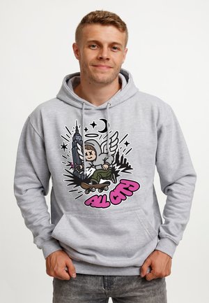 Ung mand iført lysegrå hættetrøje med grafik af vinget skateboarder og bylandskab, tekst "All City" i pink graffiti-stil.