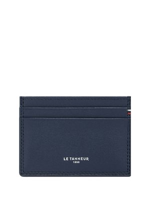 Portafoglio in pelle blu navy con quattro slot per carte, nome del marchio "LE TANNEUR 1898" in rilievo in argento e dettagli di cucitura a contrasto.