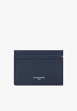 Navy leather cardholder with four card slots, embossed brand name "LE TANNEUR 1898" in silver, and contrasting stitching details.