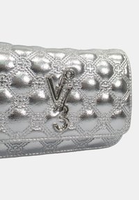 Borsa a mano metallica argento con motivo trapuntato, caratterizzata da dettagli del logo e una texture liscia. Forma compatta con un design piegato.