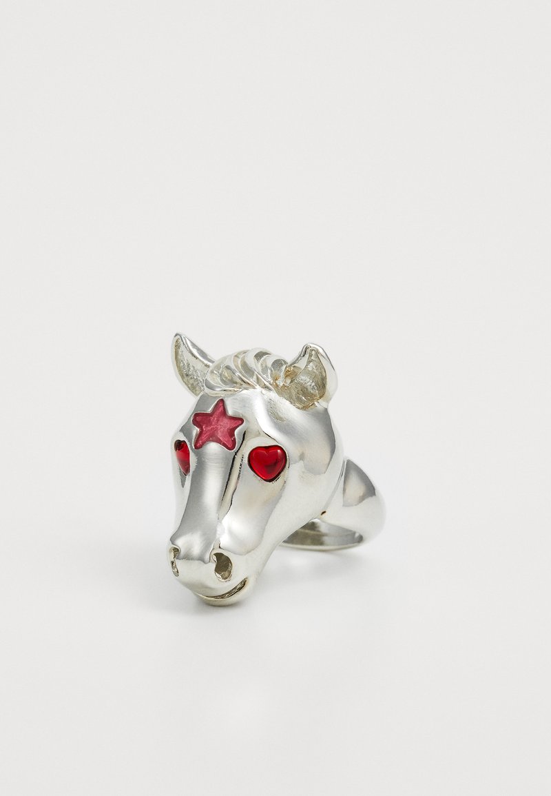 Inel în formă de cap de unicorn argintiu, cu ochi roșii în formă de inimă și un accent în formă de stea. Textură netedă, coamă detaliată și design al cornului.