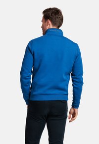 Blauwe sweatshirt met een hoge nek, ribben bij de mouwen en onderkant. Gemaakt van zachte stof, met een subtiele textuur en minimale ontwerpelementen.