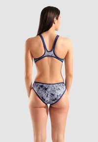 Navy- und graumusterbikini mit Racerback-Oberteil und hochgeschnittenen Unterteilen. Das Material wirkt glatt mit kontrastierenden Besätzen entlang der Kanten.