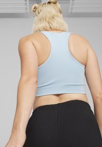 Heledad sinine sportlik crop top, millel on võidusõidujakiga disain, koos mustade elastse vöökohtaga lühikestega. Sile, elastne kangas.