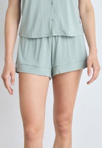 Lichtgroene, korte mouw top met knopen en bijpassende shorts, gemaakt van zachte stof, met een relaxte pasvorm en omslageinden.
