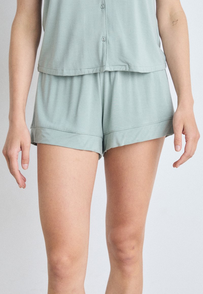 Lichtgroene, korte mouw top met knopen en bijpassende shorts, gemaakt van zachte stof, met een relaxte pasvorm en omslageinden.