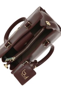 Bordeaux leren handtas met dubbele handvatten, gouden hardware, ritssluiting en een afneembare tag met reliëflogo. Getextureerde buitenkant.
