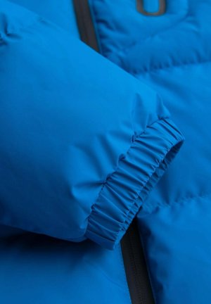 Blauwe puffy jas mouw met een elastische boord, met een gladde, glanzende textuur en een zwarte ritssluiting ernaast.