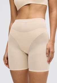 Pantaloni scurți modelatori bej cu design fără cusături și material texturat. Logo-ul Calvin Klein pe talie, lungime medie până la coapsă, croială mulată.