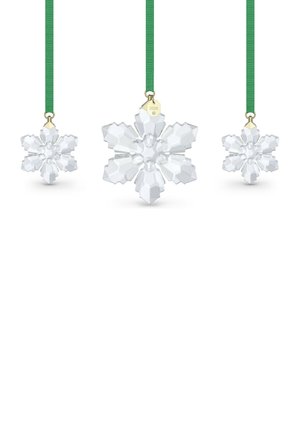Drie heldere kristallen sneeuwvlokornamenten hangend aan groene linten, de middelste met label "2026" op een gouden zeshoekige hanger.