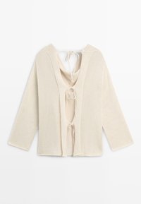 Cardigan beige en maille à ouverture devant, manches longues et trois liens à nouer au centre du dos.