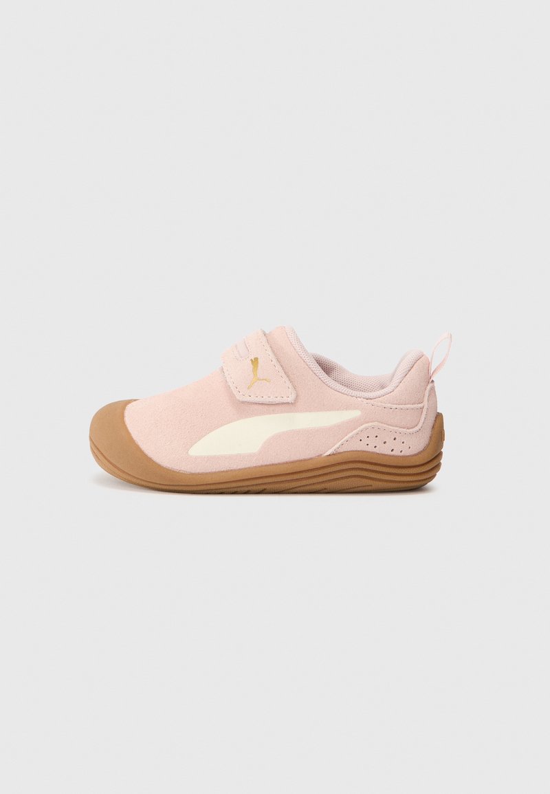 Rosa mockaläder sneakers med krämfärgade detaljer, rund tå, justerbart kardborreband och en strukturerad brun gummisula. Har en hälflik för enkel påtagning.