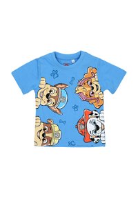 Niebieska koszulka dziecięca z czterema kolorowymi, bajkowymi twarzami psów noszących kapelusze i akcesoria, z odciskami łap i kostkami rozsianymi wokół.