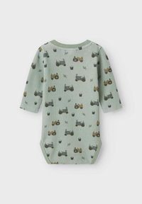 Bodysuit en coton vert, côtelé, à manches longues, avec des motifs de tracteurs et de pots dans des tons jaunes, noirs et gris.