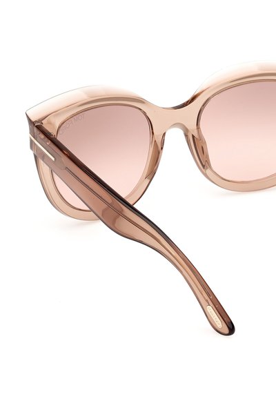 Occhiali da sole cat-eye sovradimensionati con montatura traslucida color marrone chiaro e lenti sfumate rosa. Presentano bracci eleganti e leggermente curvi.