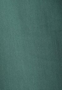 Tissu en velours teal texturé avec un motif en ribet diagonal, présentant un éclat subtil et une surface lisse. Convient à diverses applications textiles.