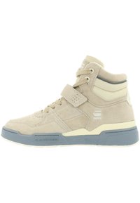 Beige hoge sneaker van suede met een textuurafwerking, voorzien van een klittenbandsluiting, een gevoerde kraag en een blauwe rubberen zool.