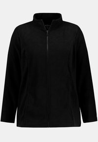Giacca in pile nera con colletto alto, zip frontale a tutta lunghezza, tasche laterali e una texture liscia. Presenta un logo sobrio sul petto.