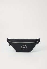 Svart nylonmidjeväska med en böjd form, silverfärgad dragkedja och vit logotyptext på framsidan. Slät textur, minimalistisk design.