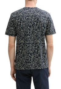 T-shirt navy avec un motif floral blanc, à manches courtes, col rond et coupe confortable. Tissu en coton avec une texture douce.