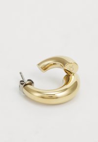 Pendiente de aro color oro con un diseño suave y redondeado y un acabado brillante. Presenta un broche en tono plateado y un discreto detalle de marca.