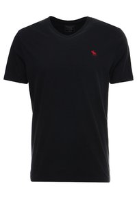 Svart T-shirt med V-hals i bomull, med korta ärmar och en liten röd logotyp på vänster bröst. Mjuk textur och klassisk passform.