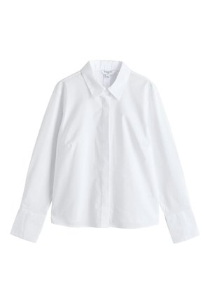 Chemise blanche à manches longues boutonnée, avec col pointu et larges poignets, présentée sur un fond blanc uni.