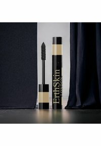 Czarna tubka tuszu do rzęs z złotymi akcentami, z teksturowanym pędzelkiem. Produkt jest oznaczony napisem "ErthSkin LONDON". Tło to ciemny materiał.