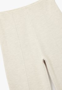 Lys beige højtaljede leggings lavet af struktureret stof, med lodrette sømme og en glat talje for komfortabel brug.