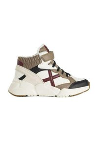 Zapatilla de caña alta con una mezcla de materiales beige, marrón, blanco y negro, secciones de malla, tobillo acolchado y una correa de velcro.