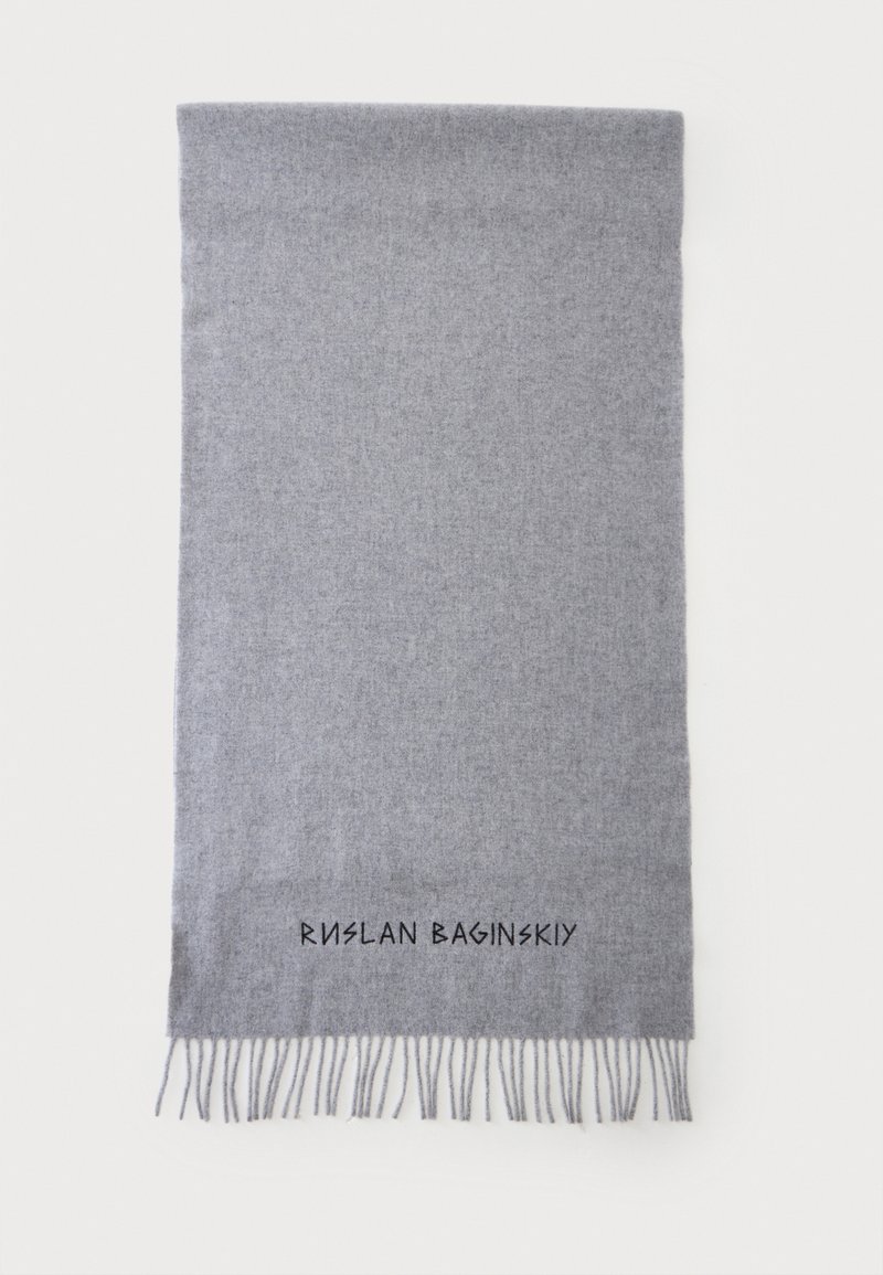 Écharpe en laine gris clair avec extrémités à franges et texte noir "Ruslan Baginskiy" brodé près du bord inférieur.