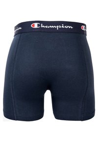 Temno modri bombažni bokserji z mehkimi elastikami v pasu, ki prikazujejo "Champion" logo v beli in rdeči barvi. Gladka tekstura, prilegajoč dizajn.