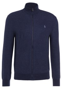 Marinblå zip-up tröja, texturerad stickad tyg, hög krage, två sidfickor, ribbad mudd och nederkant, med en liten logotyp på bröstet.