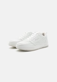 Sneaker atletiche bianche con tomaia in pelle liscia, dettagli perforati e suola in gomma testurizzata. Presentano un logo sul lato.