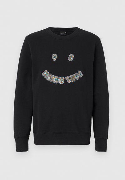 Sudadera negra de manga larga, con cuello redondo, que presenta un diseño de texto estilizado y colorido junto a una carita sonriente en la parte frontal. Textura de tela suave.