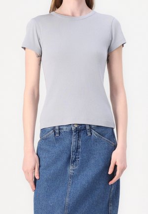 Szary prążkowany t-shirt z krótkimi rękawami, okrągłym dekoltem i dopasowanym krojem, zestawiony z wysokim stanem dżinsową spódnicą z przednimi kieszeniami.