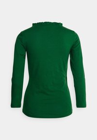 Grünes Langarmoberteil aus weichem Stoff, mit einem Rüschensaum und einer taillierten Passform. Glatte Textur ohne sichtbare Muster oder Akzente.