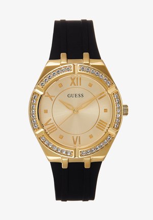 Zegarek na rękę Gold Guess z czarnym paskiem, bezelem wysadzanym kryształkami, rzymskimi cyframi oraz złotymi wskazówkami godzin, minut i sekund wskazującymi 10:10:37.