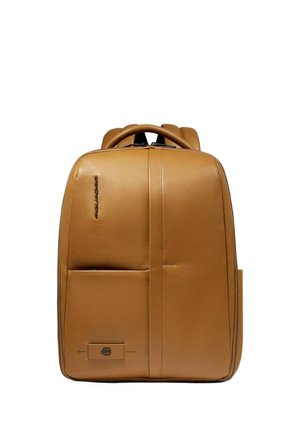 Tan leather backpack with two front pockets, a zipper closure, padded shoulder straps, and a minimalist design. Smooth texture and modern shape.