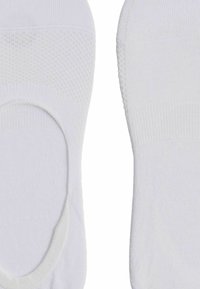 Weiße Baumwoll-No-Show-Socken mit glatter Textur, gerippten Bündchen und verstärkten Fersen- und Zehenbereichen, die für einen diskreten Tragekomfort entwickelt wurden.