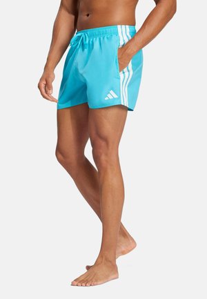 Bañador azul claro hecho de material ligero, con rayas blancas en los laterales, una cintura elástica con cordón y un bolsillo lateral.